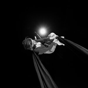 Un artiste allongé dans un faisceau de lumière rasante.
