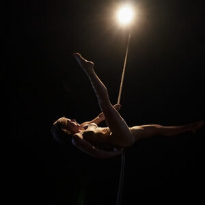 Une artiste en suspension sous une ampoule nue.