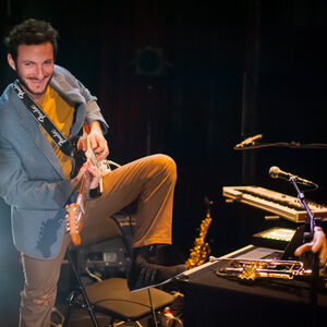 Un musicien joue du saxophone près d'un fauteuil roulant.
