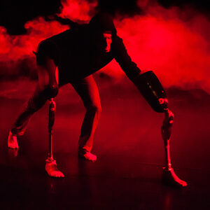 Silhouette d'une prothèse dans une fumée rouge.